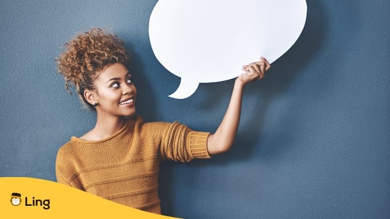 A Woman Holding A Speech Bubble Made Of White Cardboard