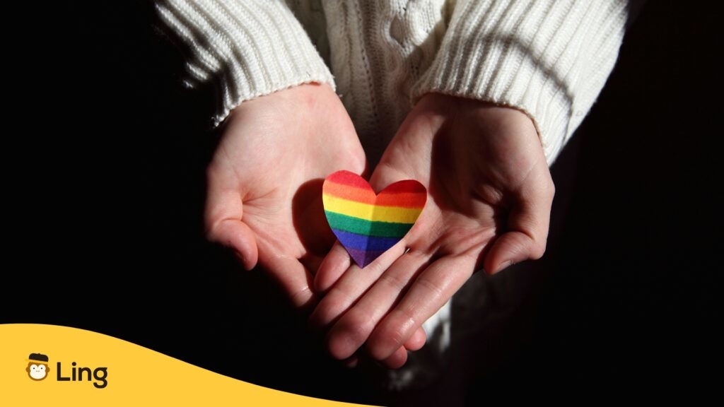 Someone Holding A Paper Heart With The Lgbtq+ Pride Flag Rainbow