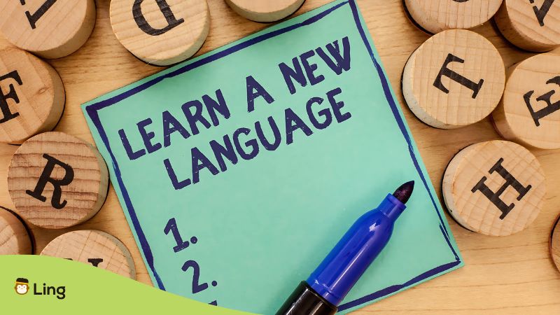 A Handwritten List Of New Languages Representing Unlimited Language Learning Apps
With Wooden Letters On The Table