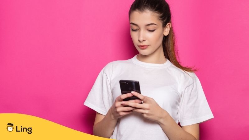 Mujer Usando El Celular Con Un Fondo Rosado