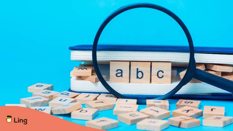 Alphabet Auf Blauem Hintergrund Verstreut, Buch Mit Abc Buchstaben Hinter Lupe