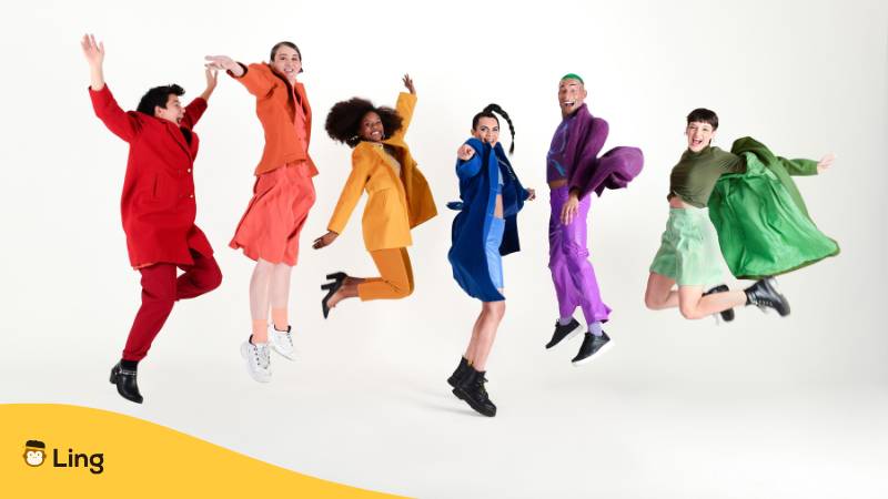 Freunde In Farbiger Kleidung Springen In Die Luft