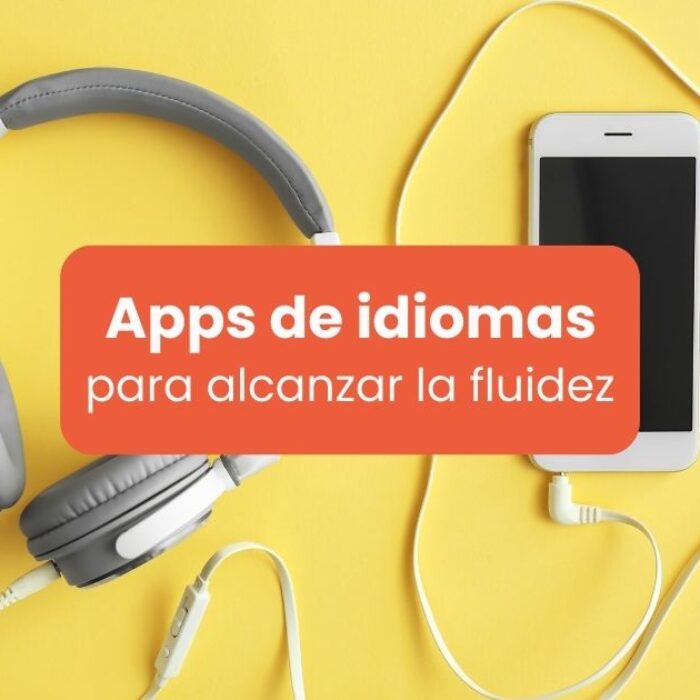 Celular y audífonos en fondo amarillo - Apps de idiomas para alcanzar la fluidez
