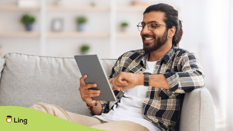 Hombre Con Lentes Sonriendo Usando Una Tablet Para Aprender Idiomas