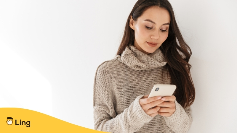 Mujer Usando Una App En Su Celular Para Alcanzar La Fluidez En Un Idioma