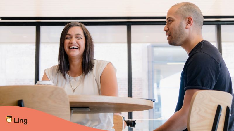 A Maori Woman And Her Male Friend Talking About A Funny Topic In A Cafe