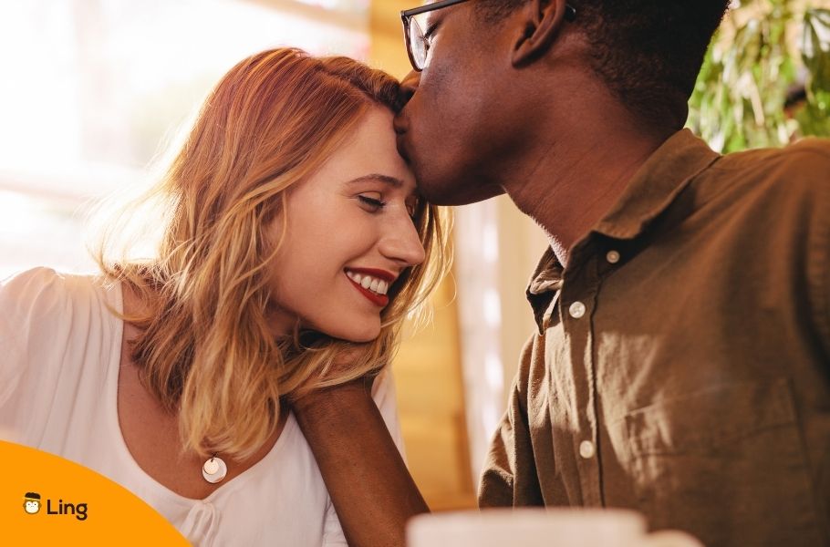 Interracial Couple With Man Kissing Woman's Forehead
