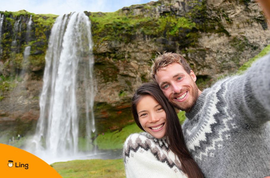 A Couple In Iceland In Front Of A Waterfall