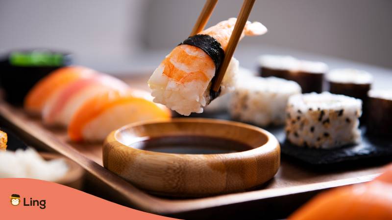 Person Tunkt Nigiri Sushi In Sojasauce
