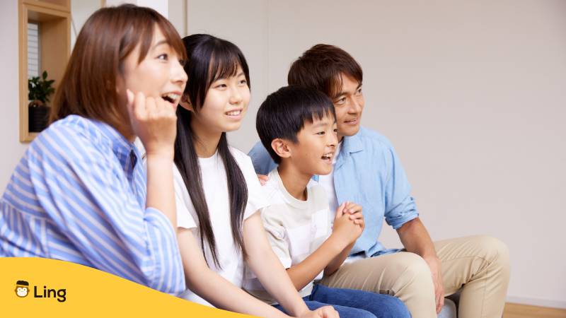 Japanische Familie Sitzt Auf Dem Sofa Und Schaut Sich Etwas An