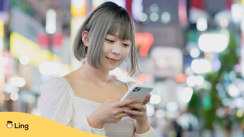 Junge Japanerin In Tokio, Tippt Auf Smartphone