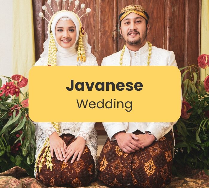 A couple posing for pictures during their Javanese wedding