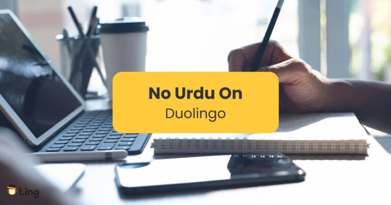 No Urdu On Duolingo - Someone Writing On A Notebook With A Laptop And A Phone On A Desk