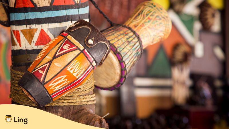 Tambours Africains Accrochés À Un Tronc D'arbre Décoré De Motifs Colorés