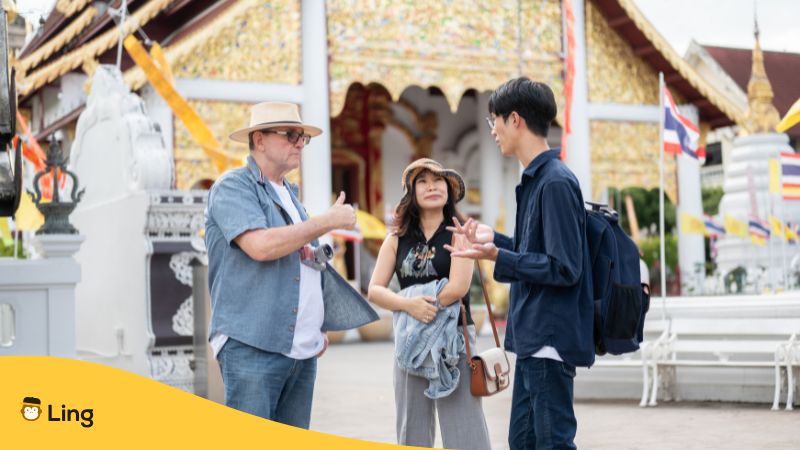 Tourists Speaking In Thai With A Thai Local In A Thai Buddhist Temple