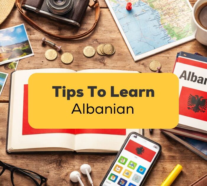 Open notebook on a wooden surface with the Albanian flag- tips to learn Albanian