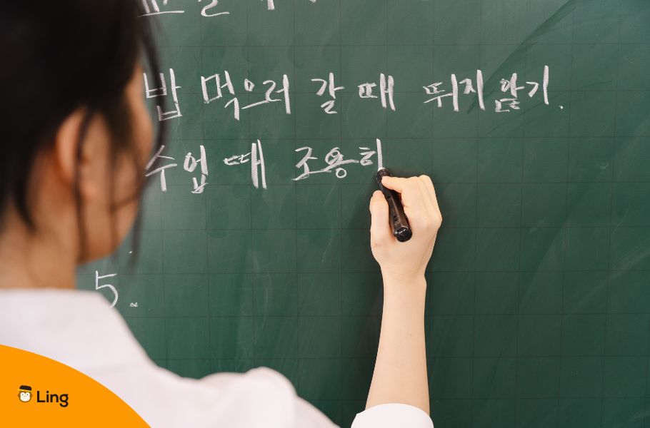An Image Of A Woman Writing In The Korean Script On A Blackboard