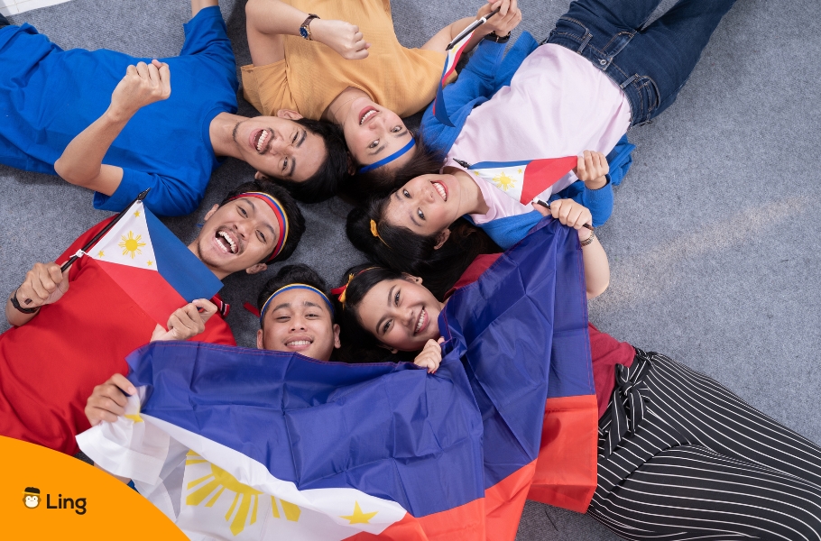 A Group Of Young Adults Holding Filipino Flags Representing The Top 3 Languages In The Philippines
