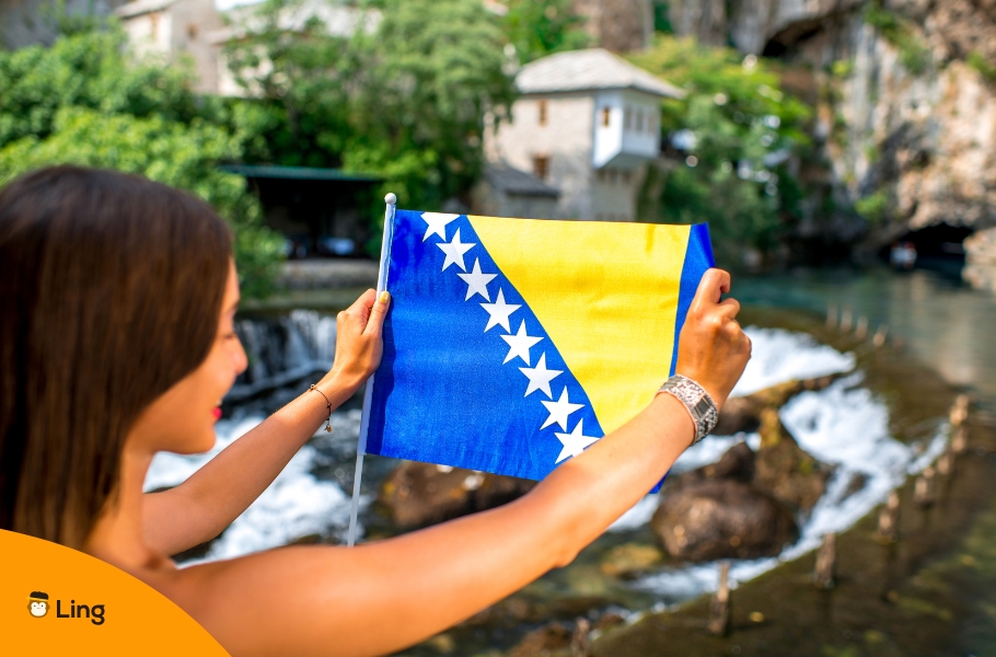 A Woman Holding Bosnian Flag Against A Scenic Spot