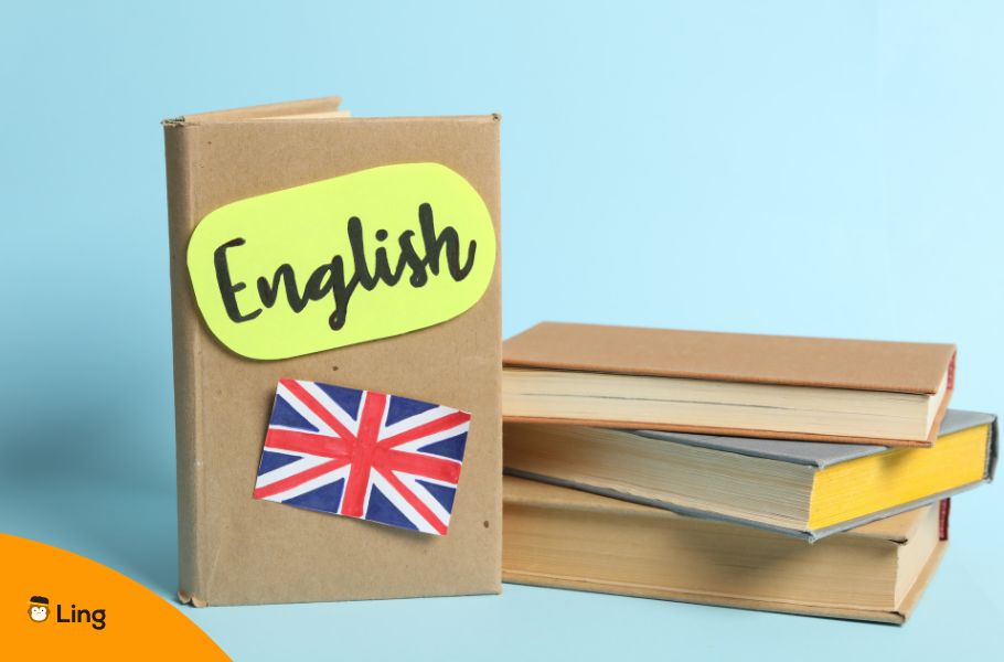 Book With The Word &Quot;English&Quot; And The Union Jack On It And Stack Of Books On Light Blue Background