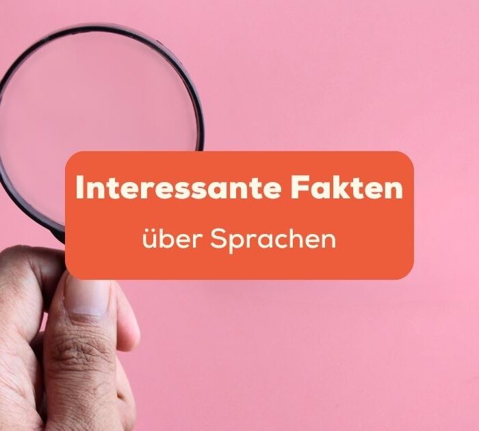 Hand, die eine Lupe über rosa Untergrund hält. Entdecke über 50 interessante Fakten über Sprachen mit Ling.