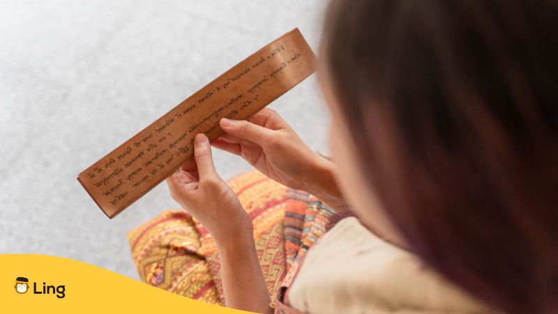 Junge Asiatin, Die Altes Sanskrit-Buch Aus Dem Tripitaka Über Den Dhamma Des Buddha Liest