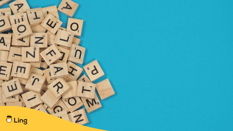 Buchstabenplättchen Aus Holz Liegen Auf Einem Leuchtend Blauen Untergrund.