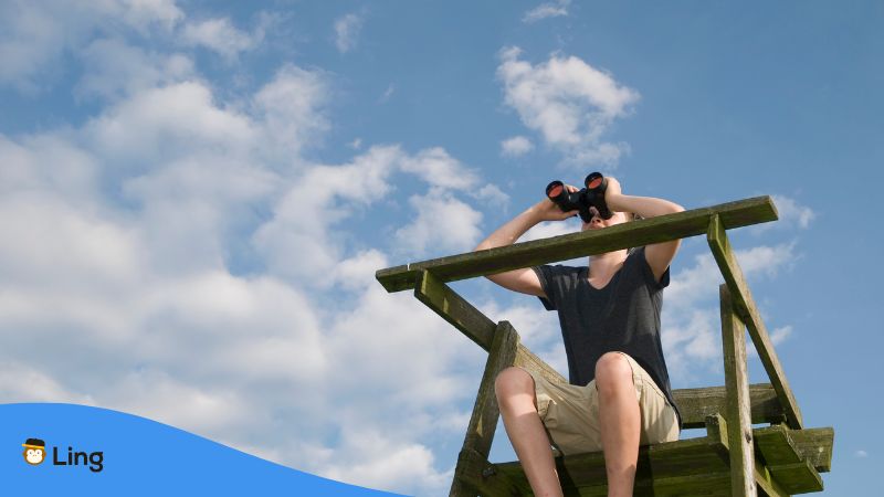 Junger Mann Verschafft Sich Mit Einem Fernglas Einen Überblick.