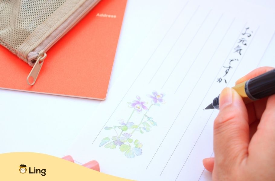Main Écrivant Des Caractères Japonais Sur Du Papier À Lettre Fleuri
Prononciation En Japonais