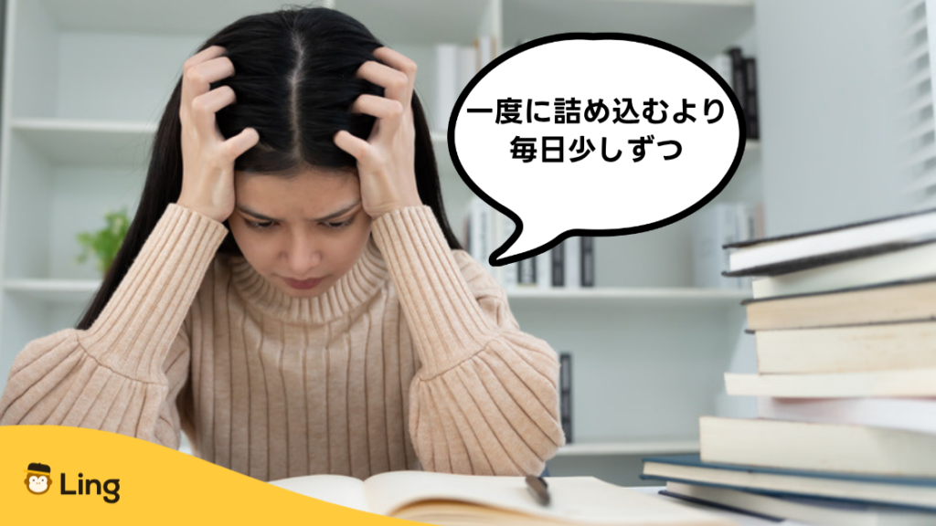本に囲まれて頭を抱える女性:一度に詰め込むより毎日少しずつ
