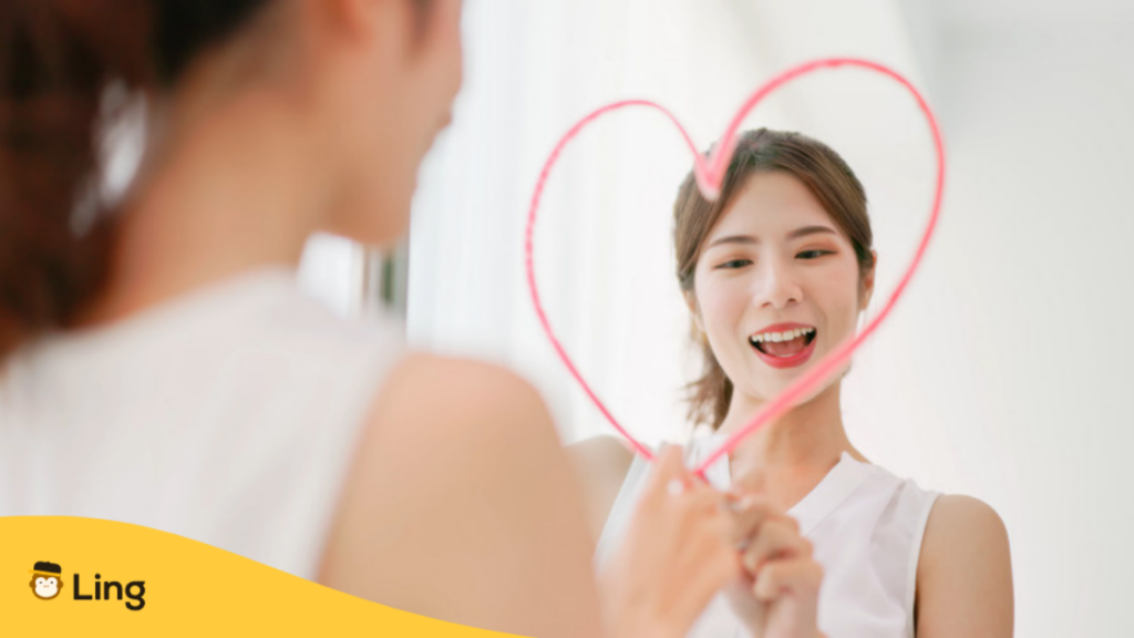 鏡の前で笑顔で話す練習をする女性