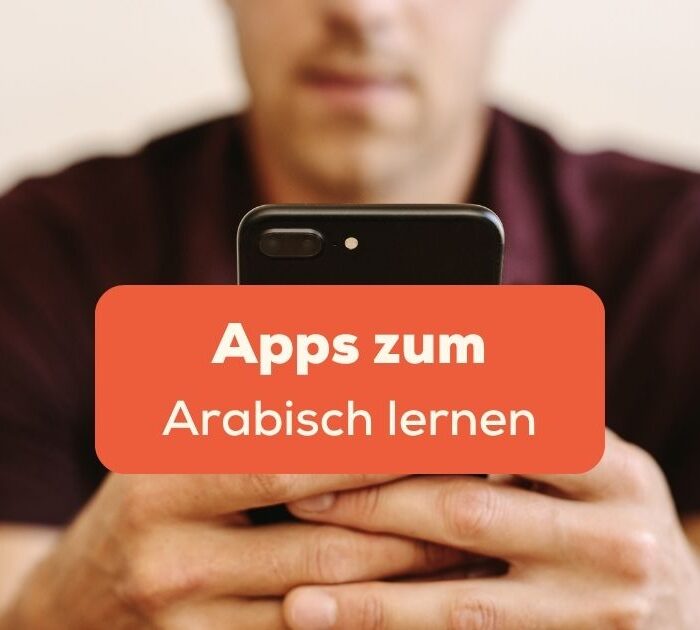 Mann sitzt am Handy und sucht die besten Apps zum Arabisch lernen.