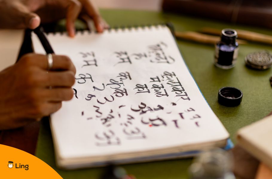 A Hand Writing Hindi In A Notebook