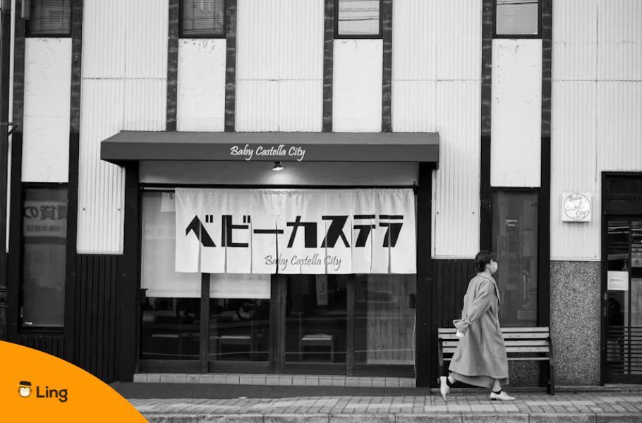 Black And White Photo Of A Japanese Shop Displaying A Sign Written In Katakana