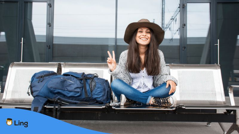 Reisende Frau Mit Hut, Sitzt Mit Ihrem Rucksack Auf Einer Bank.