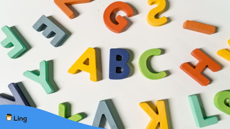 Bunte Holzbuchstaben Auf Weißem Untergrund.