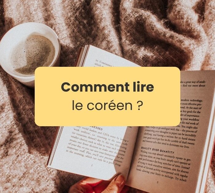 Lire le coréen Un livre ouvert posé tenu par une main sur un tapis de style cosy à coté d'une tasse de thé